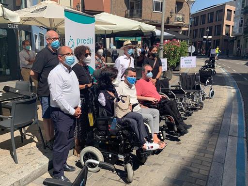 Miembros de ASPAYM, PREDIF y el Ayuntamiento de Valladolid posan para los medios en aparcamientos ocupados por sillas de ruedas