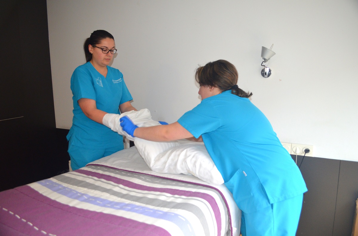 Personal de la residencia haciendo una habitación de la misma