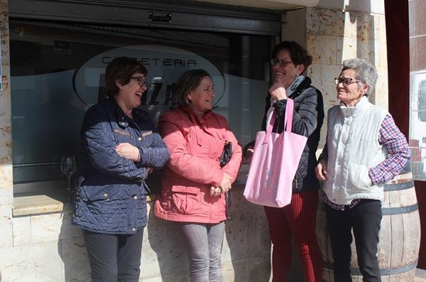 Tres señoras mayores, charlando alegres al lado de una cafetería