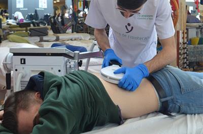 Usuario, tumbado en una camilla, en sesión de rehabilitación