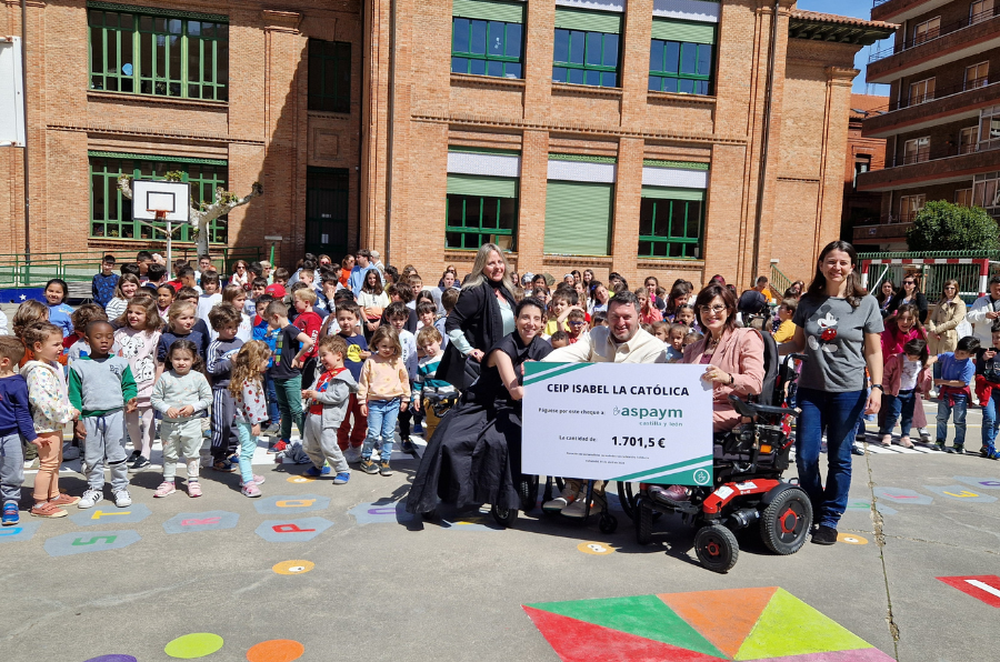 La directiva del CEIP Isabel la Católica hace entrega a miembros de ASPAYM CyL del cheque solidario