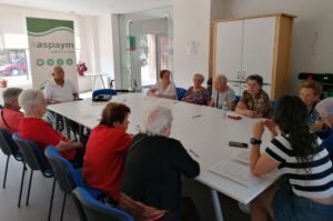 Participantes de la segunda sesión de ASPAYM Mayores en Villadiego realizan la actividad alrededor de la mesa