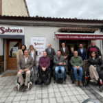 Asistentes a la entrega del premio CERMI a Saborea Castilla y León posan en la entrada de la tienda